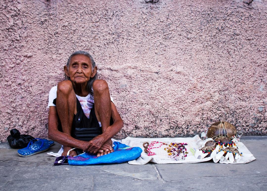 I was walking downtown in Iquitos, Peru, when I saw this older lady selling her crafts. It caught my attention the way how she sat  holding her legs towards her  as if subconsciously she was trying to hold her whole existence together.  I approached her and I gave her some money in exchange for some pictures of her. Confused, she agreed.  This picture reminds me of the strength and fragility of human existence. This lady called Emma, at ninety two, she still was fighting. Her quiet strength was worthy of my admiration.