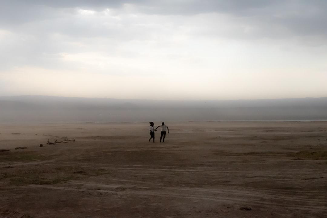 Couple in a sandstorm in Nakuru National Park during a safari in Kenya, Africa.